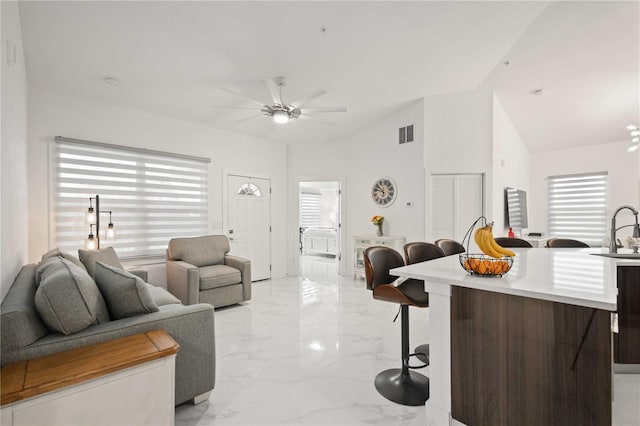 living room with plenty of natural light, ceiling fan, and sink