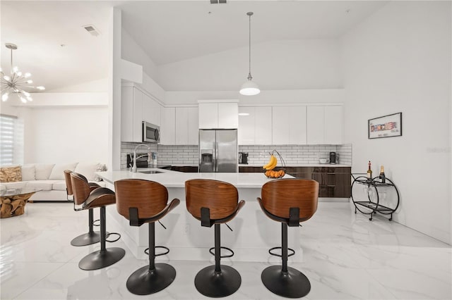 kitchen with decorative backsplash, sink, stainless steel appliances, and vaulted ceiling