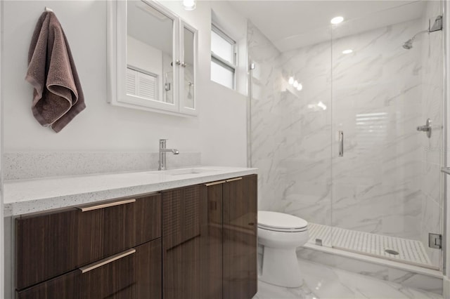 bathroom featuring vanity, toilet, and a shower with shower door