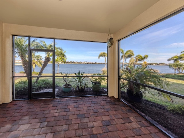 unfurnished sunroom featuring a water view