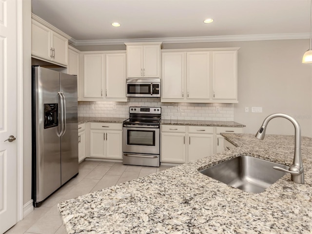 kitchen with hanging light fixtures, light stone countertops, sink, and appliances with stainless steel finishes