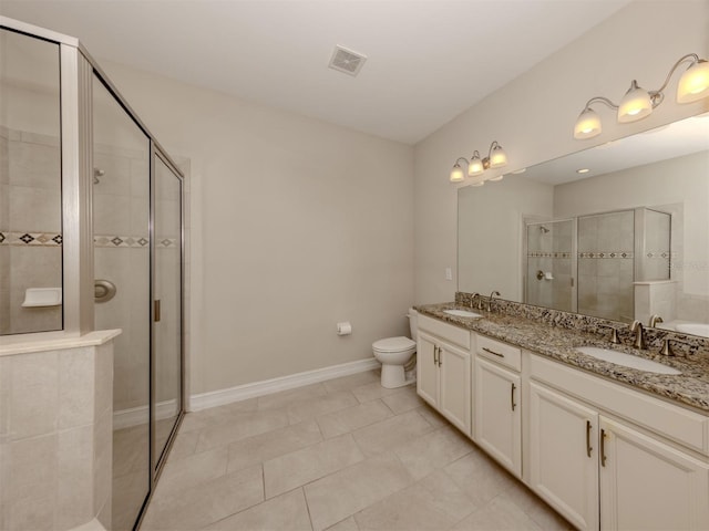 bathroom featuring tile patterned floors, vanity, toilet, and a shower with door