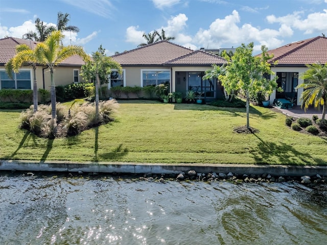 view of front of property with a water view and a front lawn