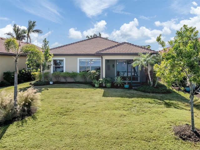 rear view of property featuring a lawn