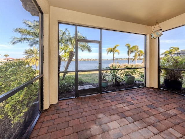 unfurnished sunroom featuring a water view