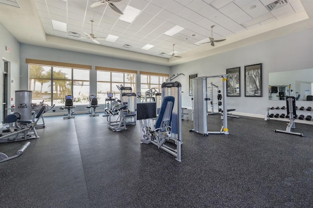 gym with a raised ceiling, a drop ceiling, and a healthy amount of sunlight