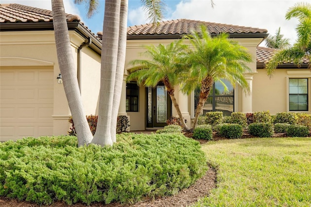 doorway to property with a yard and a garage