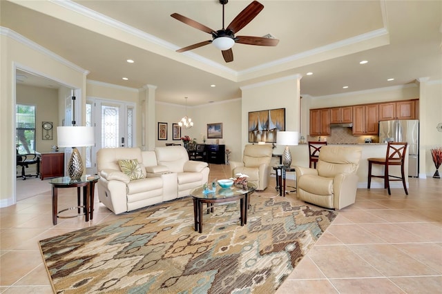 tiled living room featuring a raised ceiling, crown molding, and ceiling fan with notable chandelier