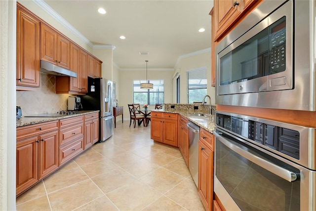 kitchen featuring light stone countertops, appliances with stainless steel finishes, decorative light fixtures, and ornamental molding