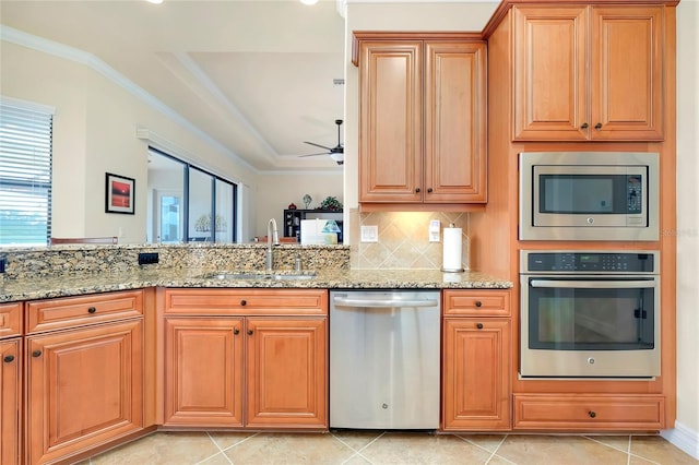 kitchen with sink, light stone counters, decorative backsplash, light tile patterned floors, and appliances with stainless steel finishes