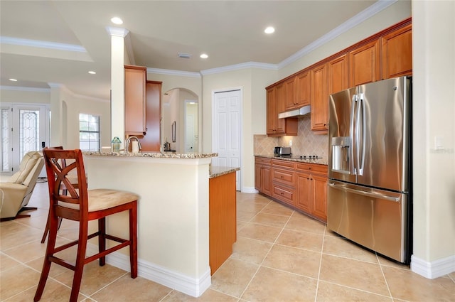 kitchen featuring kitchen peninsula, light stone counters, stainless steel refrigerator with ice dispenser, and ornamental molding