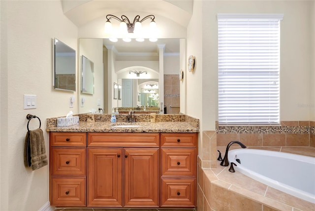 bathroom featuring vanity, a relaxing tiled tub, and ornamental molding