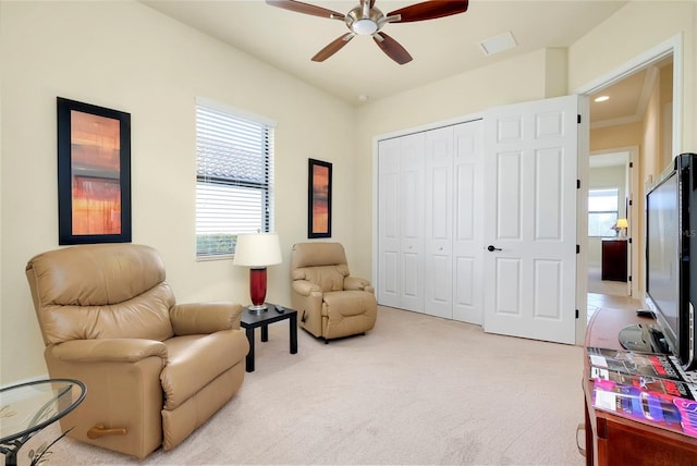 sitting room with ceiling fan, carpet floors, and a healthy amount of sunlight