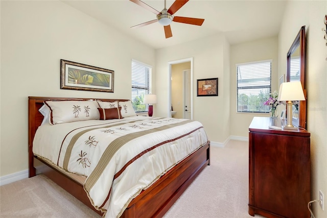 bedroom with light carpet, multiple windows, and ceiling fan