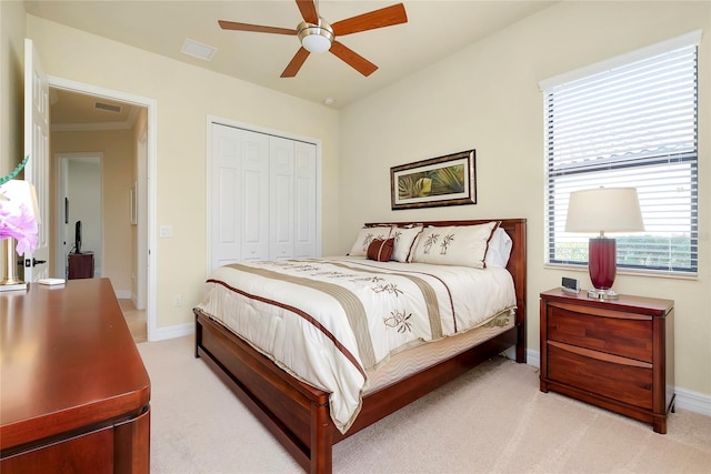 bedroom featuring light colored carpet, a closet, crown molding, and ceiling fan