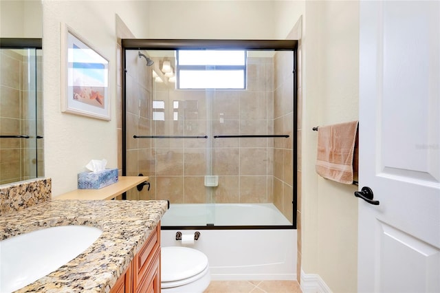 full bathroom with shower / bath combination with glass door, tile patterned flooring, vanity, and toilet