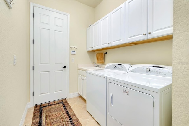 washroom with cabinets, sink, light tile patterned flooring, and washer and dryer