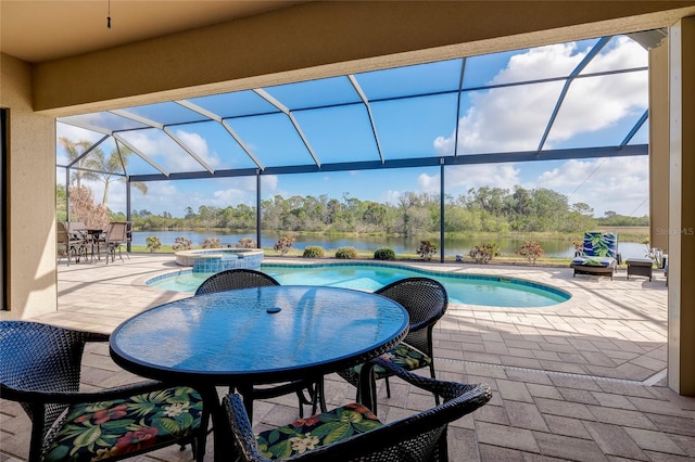 view of pool featuring glass enclosure, an in ground hot tub, a patio area, and a water view