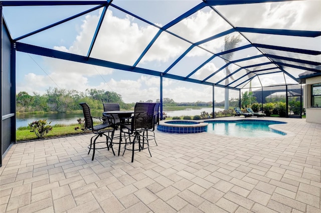 view of pool with glass enclosure, an in ground hot tub, a patio area, and a water view