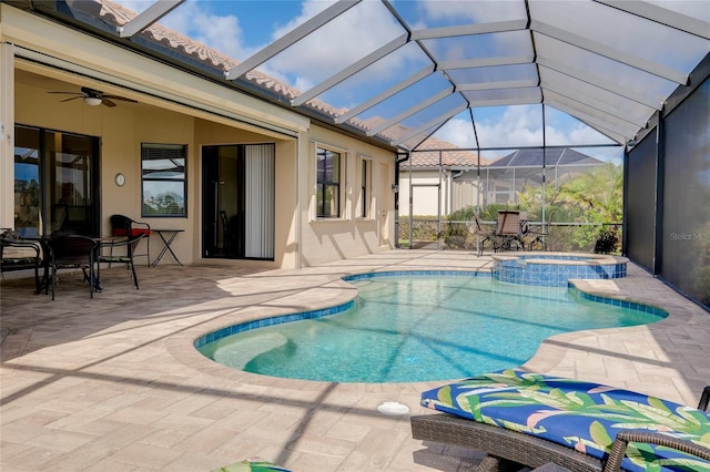 view of pool featuring an in ground hot tub, glass enclosure, ceiling fan, and a patio area