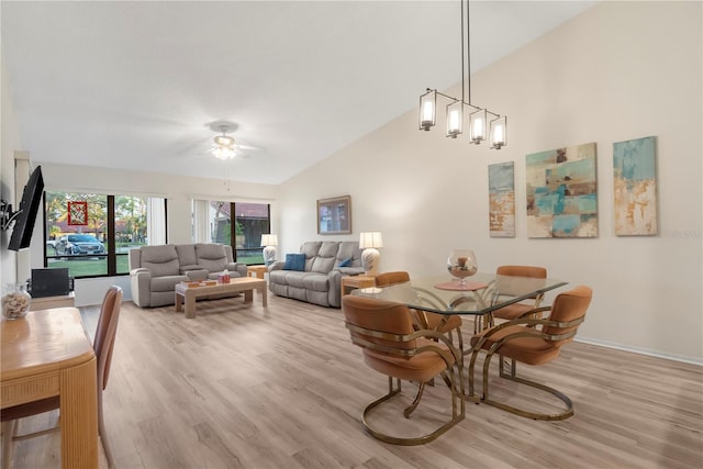 dining space featuring ceiling fan, light hardwood / wood-style floors, and vaulted ceiling