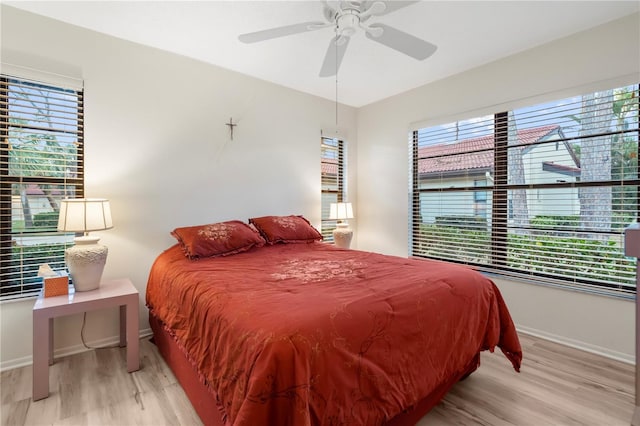 bedroom featuring multiple windows, light hardwood / wood-style flooring, and ceiling fan