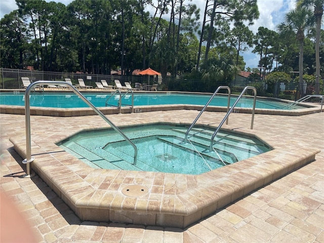 view of swimming pool with a community hot tub and a patio