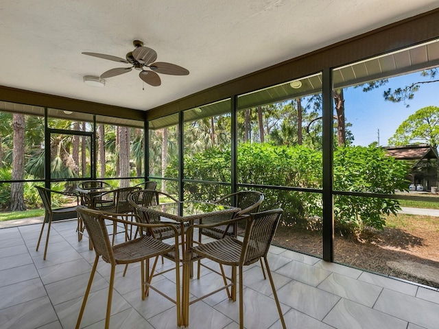 unfurnished sunroom featuring ceiling fan