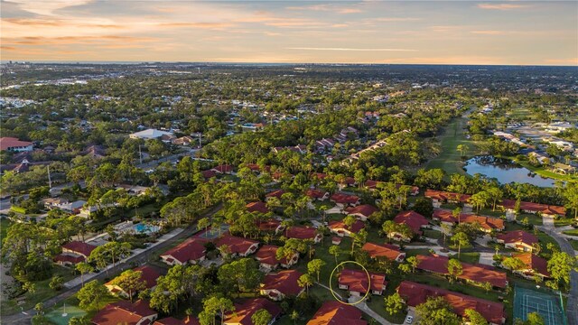 aerial view at dusk featuring a water view