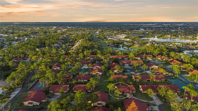 aerial view at dusk featuring a water view