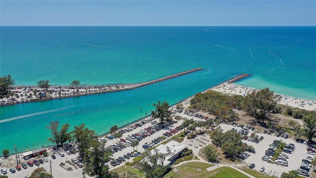 birds eye view of property with a water view and a beach view