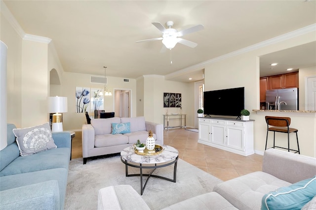 tiled living room featuring ceiling fan with notable chandelier and ornamental molding