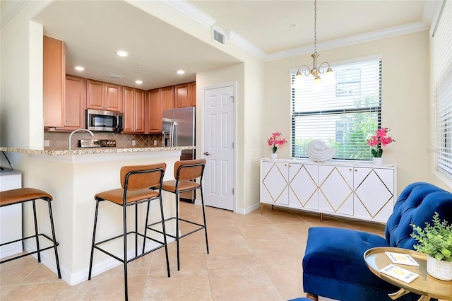 kitchen featuring an inviting chandelier, kitchen peninsula, decorative light fixtures, a kitchen bar, and appliances with stainless steel finishes