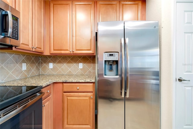 kitchen featuring appliances with stainless steel finishes, tasteful backsplash, and light stone counters