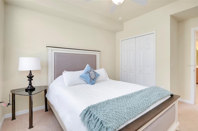 bedroom with ceiling fan, a closet, and light colored carpet