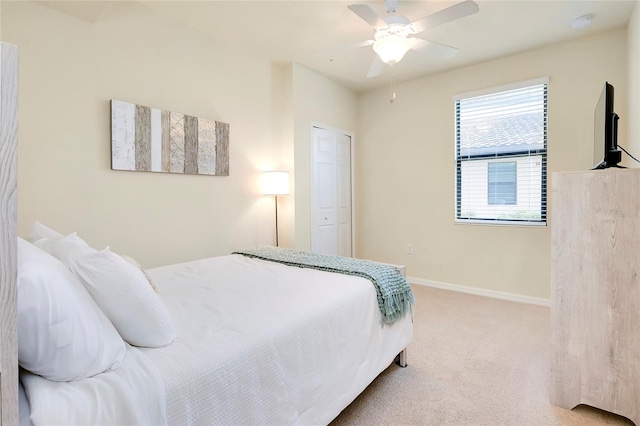 carpeted bedroom featuring ceiling fan and a closet