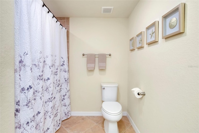 bathroom featuring toilet, tile patterned floors, and walk in shower