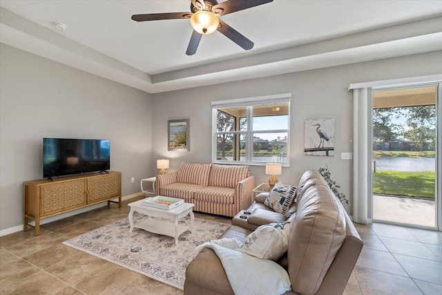 tiled living room featuring a water view and ceiling fan