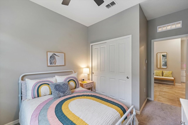 bedroom featuring a closet, light colored carpet, and ceiling fan