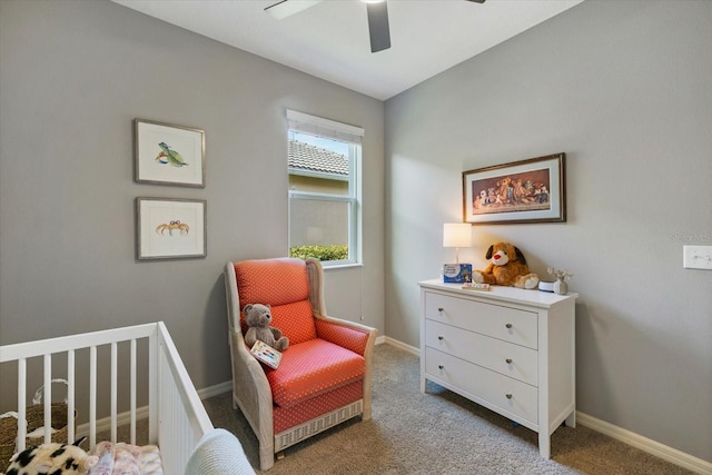 bedroom featuring ceiling fan, light colored carpet, and a nursery area