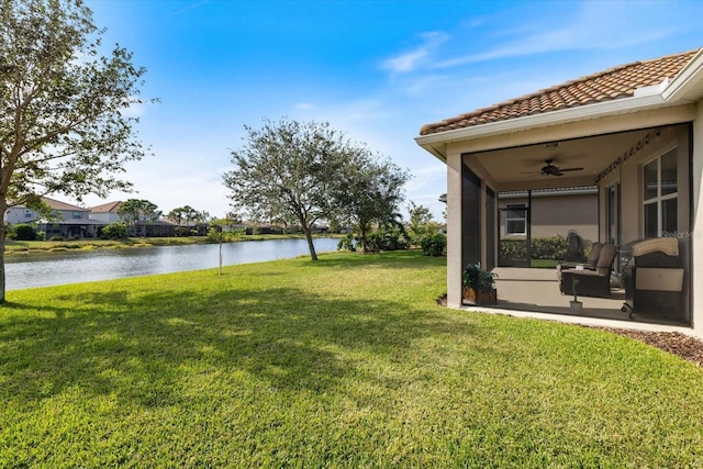 view of yard with a water view and ceiling fan