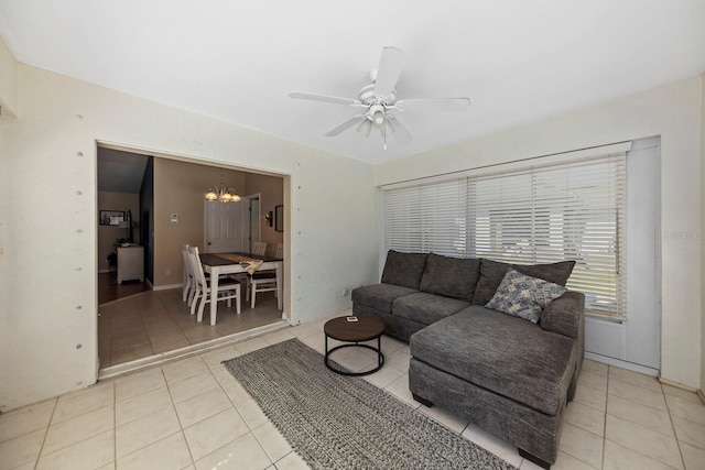 living room featuring ceiling fan with notable chandelier and light tile patterned floors