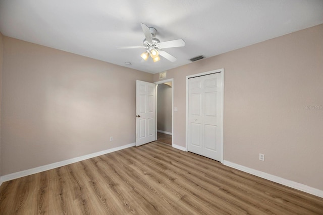 unfurnished bedroom with a closet, light hardwood / wood-style floors, and ceiling fan