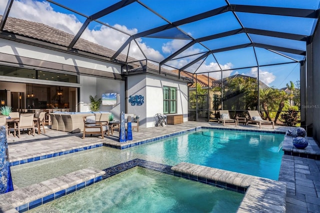 view of pool featuring glass enclosure, a patio area, and an in ground hot tub