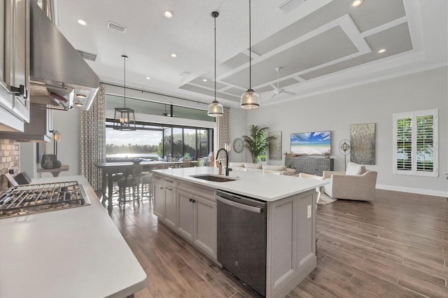 kitchen featuring a center island with sink, exhaust hood, sink, and appliances with stainless steel finishes