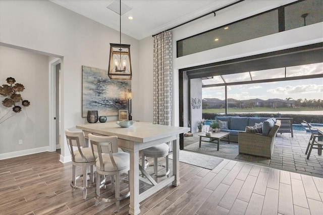 dining area with hardwood / wood-style floors and high vaulted ceiling