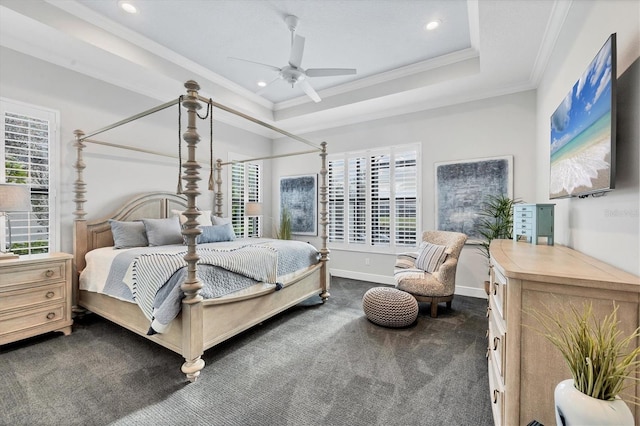 bedroom with a tray ceiling, dark carpet, ceiling fan, and ornamental molding