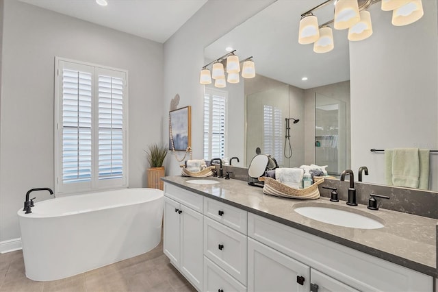 bathroom with tile patterned floors, vanity, shower with separate bathtub, and a wealth of natural light