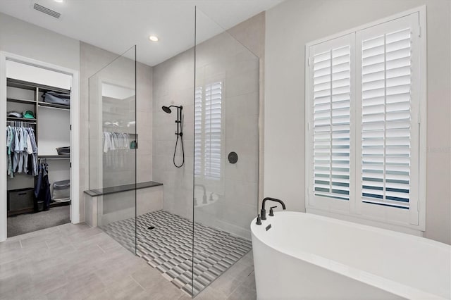 bathroom with tile patterned flooring and independent shower and bath