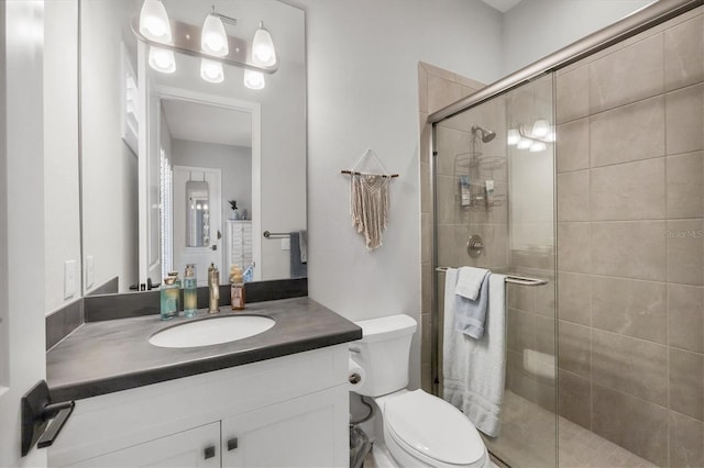 bathroom with vanity, toilet, and an enclosed shower